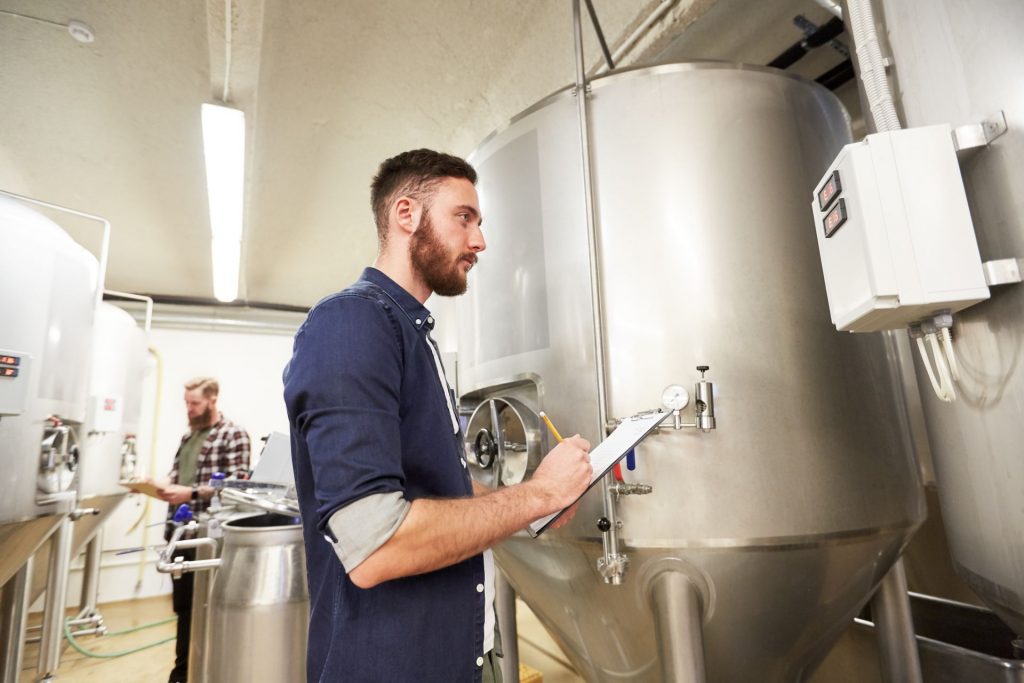 men with clipboard at craft brewery or beer plant PRQ66MY